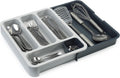 Expandable dark-gray six-compartment plastic cutlery drawer tray — expanded tray with cutlery