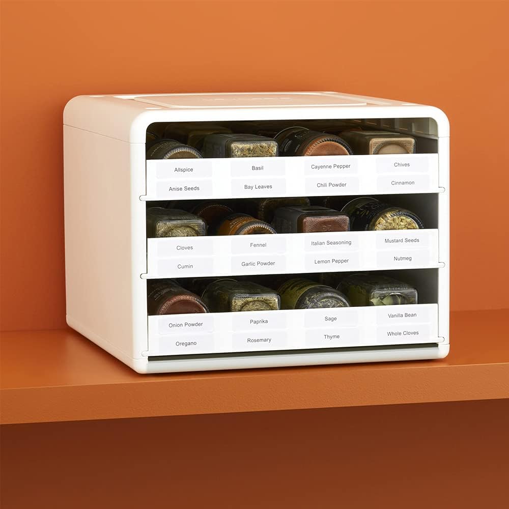 White adjustable pull-down spice organizer with drawer labels — organizer filled with labeled spice jars