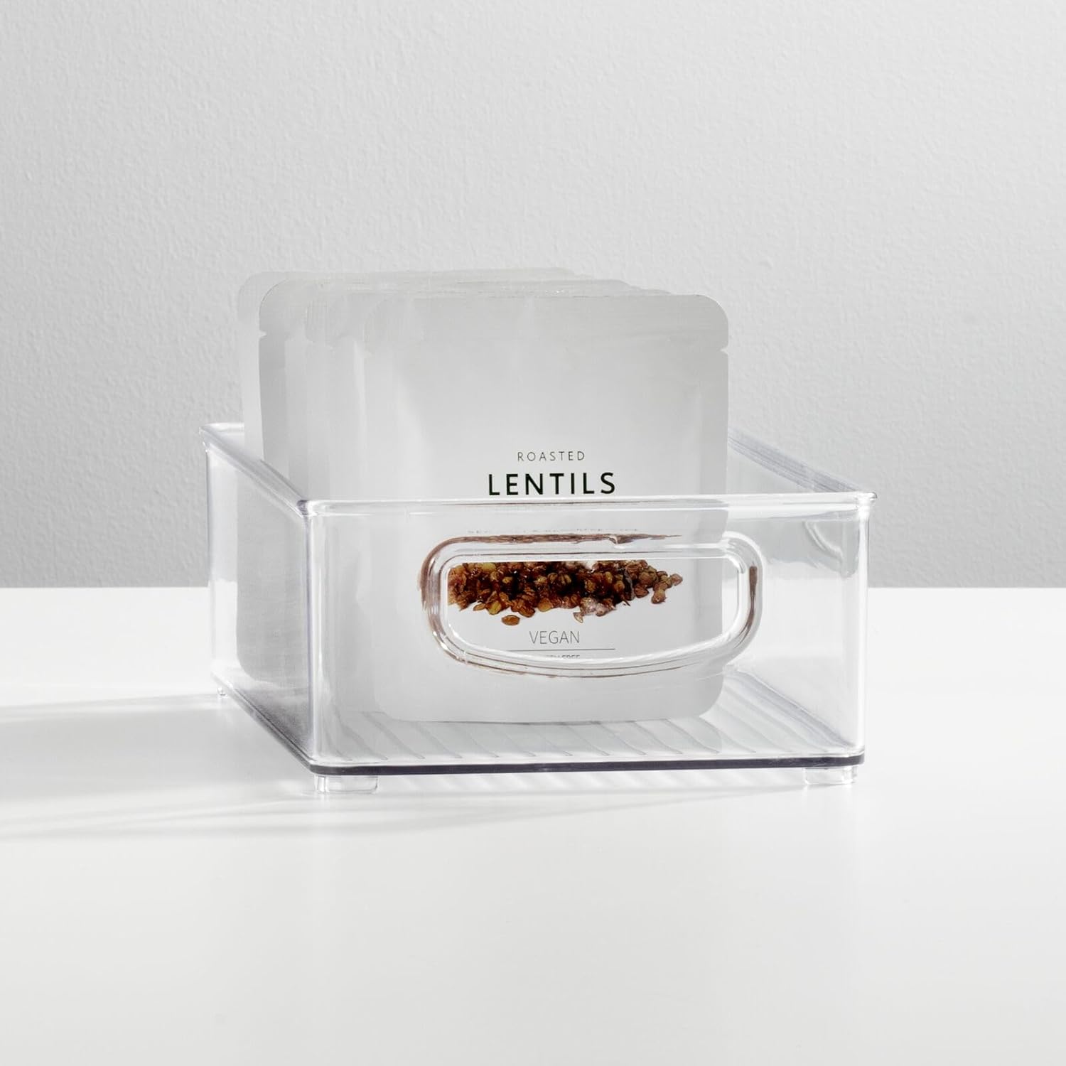 Two clear plastic handled storage bins for pantry or refrigerator organization — clear bin used for pantry storage